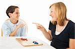 Brother and sister having fun playing board games.  Isolated on white.