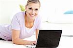 Positive woman using her laptop on the floor in the living room
