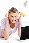 Aggressive young woman using her laptop in the living room