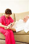 Home health nurse taking an elderly patient's pulse.