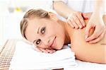 Smiling caucasian woman receiving an acupuncture treatment in a health spa