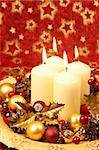 Christmas decoration with four candles on red Christmas background. Shallow DOF, copy space