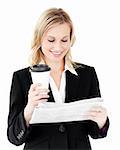 Happy businesswoman reading the newspaper holding coffee against white background