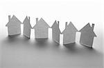 close up of houses cut out of paper on white background