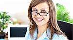 Glwoing caucasian businesswoman sitting in her office smiling at the camera