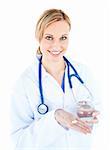 Pretty female doctor holding pills and water against white background