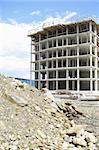 wide view of engineering architectural development outdoors unfinished exterior building in construction , machinery and material