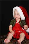 Cute blond girl wearing a red dress and christmas hat