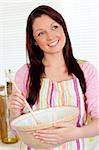 Positive woman cooking at home in the kitchen