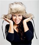 Adorable young woman smilling and wearing a fur hat