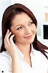 Positive businesswoman talking on phone sitting in her office