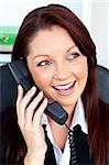 Attractive businesswoman talking on phone sitting in her office