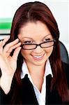 Smiling businesswoman holding her glasses sitting in her office at her desk