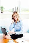 smiling business woman on phone working at home with laptop sitting in the living-room