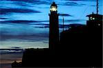 A view of "El Morro" lighthouse in Havana, against dramatic sunset sky