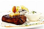 Juicy steak with garlic butter on a white place