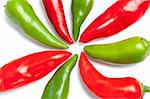 Green and red hot peppers close up arranged in shape of sun rays isolated on white background