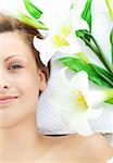 Beautiful woman lying on a massage table in a spa with flowers