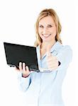 Jolly young businesswoman holding a laptop with thumb up against white background