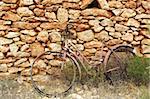 aged weathered bicycle vintage masonry stone wall in Formentera Balearic islands