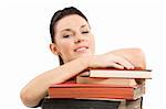 close up portrait of young and cute brunette student posing her head over a pile of old book