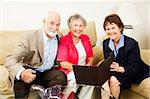 Pretty saleswoman meets with happy senior couple in their home.