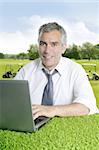 senior businessman golf course working computer green grass desk