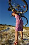 The girl bears a bicycle uphill