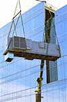 crane lifting cooling unit air conditioning system up the side of glass  building