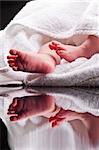 Bare baby feet wrapped in a white towel