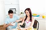 Young caucasian couple having breakfast together in the kitchen at home