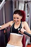 Charming athletic woman using a bench press in a fitness center