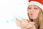 Beautiful santa girl blowing to snowflakes at her hands isolated on white background