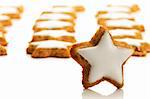 one star shaped cinnamon biscuit in front of many on white background