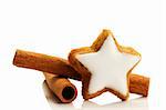 star shaped cinnamon biscuit and cinnamon sticks on white background