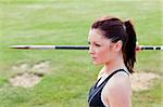 Concentrated athletic woman ready to throw the javelin in a stadium