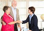 Senior couple meets with a friendly financial adviser.