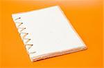 recycled notepad over an orange background