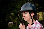 Female Costa Rican tourist putting on equestrian helmet