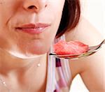 Young woman eating a slice of watermelon.