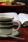 Morning coffee with the Bible and fruits in background. Shallow dof