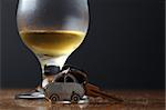 Car key with car-shaped pendant and a glass of beer
