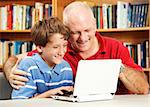 Father and son in the library using a small netbook computer.