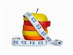 Slices of apples and orange as one fruit and a measuring tape. Isolated with clipping path.