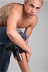 A young, muscular brazilian man in a studio shot on a gray background.