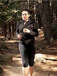 Young woman running in woods, outdoor background