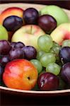 Bowl with fresh organic apples, nectarines, grapes and plums. Shallow dof