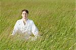 A man sits quietly in the grass