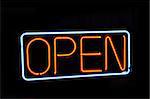 Neon open sign against a black night background