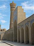 A number of arches and a minaret against blue sky